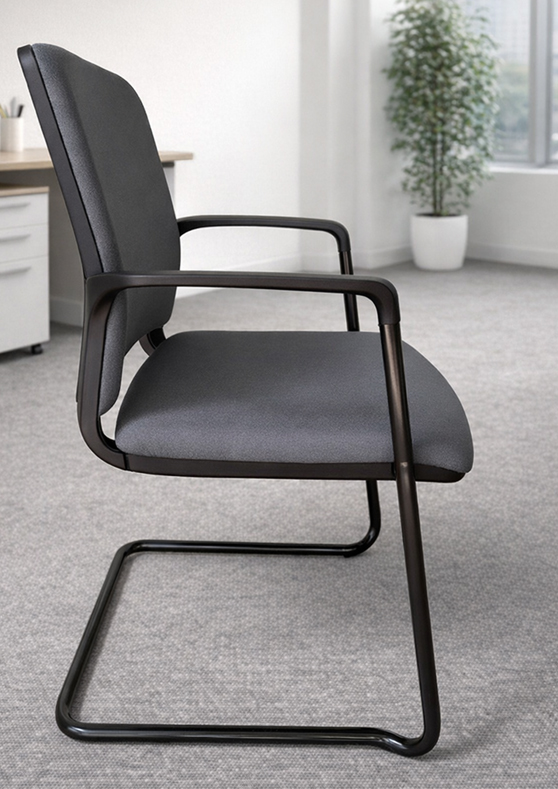 MAT - Cantilever Conference Chair 5 MAT Conference Office Chair with a black cantilever frame and dark gray upholstered padding positioned beside a white office desk and filing cabinet in a modern workspace.
