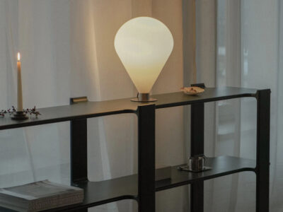 Minimalist Ely table lamp on modern shelving unit with warm ambient lighting and contemporary décor.